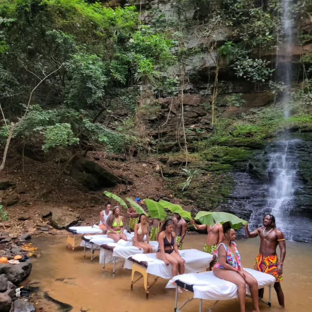 Group massage experience with waterfall and tropical foliage